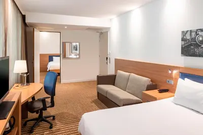a hotel room with a bed and a desk at Hampton by Hilton Amsterdam Airport Schiphol in Hoofddorp