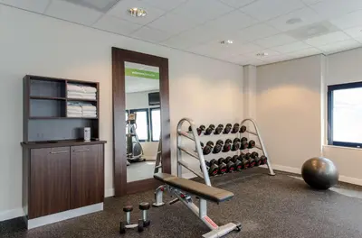 a room with a gym with a treadmill and weights at Hampton by Hilton Amsterdam Airport Schiphol in Hoofddorp