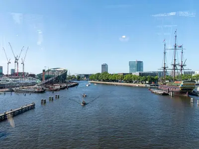 a river with boats in the water and a city at SWEETS - Kortjewantsbrug in Amsterdam