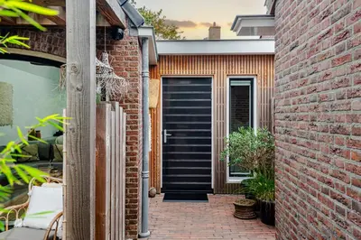 a brick house with a black front door at Suite-Suite luxury private guesthouse in Zandvoort
