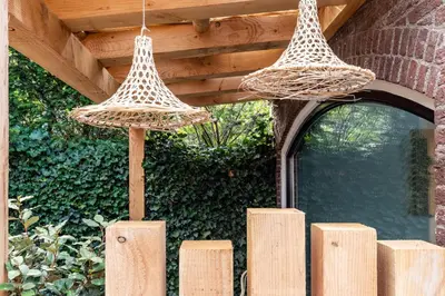 two baskets hanging over a wooden fence in a garden at Suite-Suite luxury private guesthouse in Zandvoort