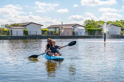 a woman and a child in a paddle boat on the water at EuroParcs de Woudhoeve in Egmond aan den Hoef