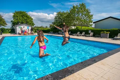 two girls jumping into a swimming pool at EuroParcs de Woudhoeve in Egmond aan den Hoef