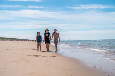 three women walking on the beach at EuroParcs de Woudhoeve in Egmond aan den Hoef