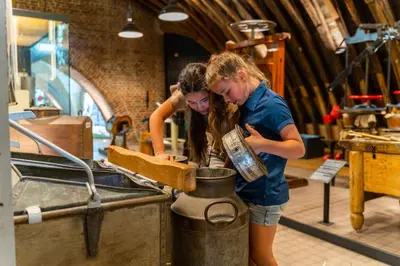 two girls are preparing food in a kitchen at EuroParcs de Woudhoeve in Egmond aan den Hoef
