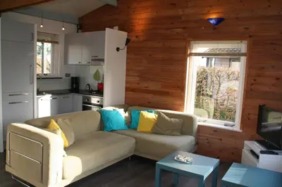 a living room with a couch and a kitchen at Rekerlanden 154 in Schoorldam