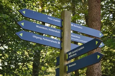 a street sign with arrows pointing in different directions at Gasterij Leyduin in Vogelenzang
