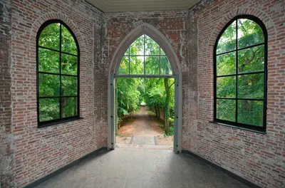 an empty room with two windows and a brick wall at Gasterij Leyduin in Vogelenzang