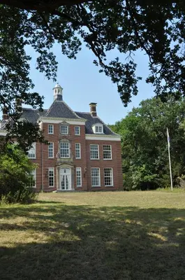 a large red brick house with a roof at Gasterij Leyduin in Vogelenzang