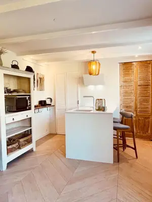 a kitchen with a white island and a table at Zandvoort Paradise Boutique Chambre in Zandvoort