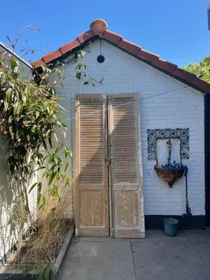 a small shed with wooden doors on the side of it at Zandvoort Paradise Boutique Chambre in Zandvoort