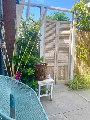 a patio with a bench and a wooden fence at Zandvoort Paradise Boutique Chambre in Zandvoort