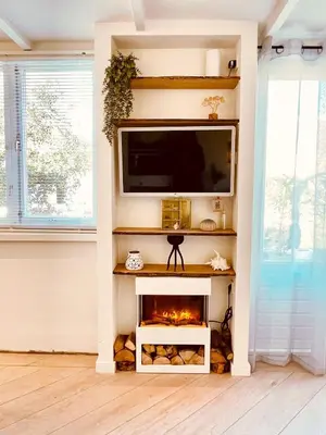 a living room with a fireplace and a tv at Zandvoort Paradise Boutique Chambre in Zandvoort