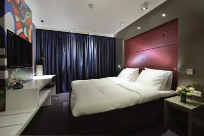 a bedroom with a large bed with a red headboard at Blue Mansion Hotel in Aalsmeer
