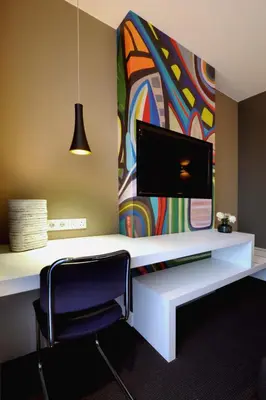 a desk with a tv and a chair in a room at Blue Mansion Hotel in Aalsmeer