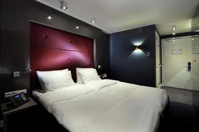 a bedroom with a large white bed with a red headboard at Blue Mansion Hotel in Aalsmeer