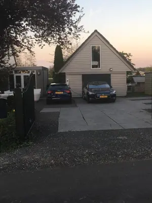 two cars parked in front of a garage at Aan de Vecht in Nederhorst den Berg
