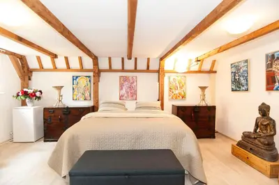 a bedroom with a bed with a table and paintings at Bed & Breakfast of Art in Amsterdam