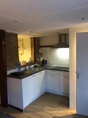 a kitchen with white cabinets and a sink at B&B CaSandra in Volendam