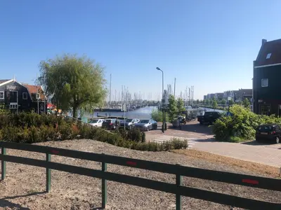 a view of a river with cars parked in a parking lot at B&B CaSandra in Volendam