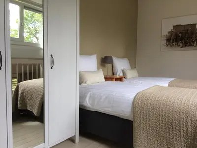 a bedroom with two beds and a mirror at Lelymare Logies in Lelystad