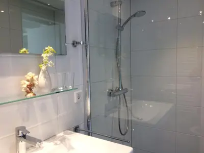 a bathroom with a shower and a sink at Lelymare Logies in Lelystad