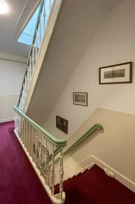 a staircase with a green handrail in a house at Central Rooftop Terrace Guest Suite in Amsterdam