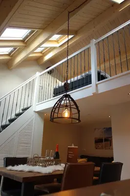 a dining room with a staircase and a light fixture at Albatros in Schoorl