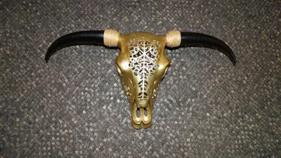 a gold goat head with horns on the ground at Carpe Diem in Zandvoort