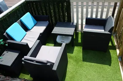 a balcony with three chairs and a table and grass at Sleep Inn Amsterdam in Amsterdam