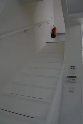 a white staircase in a building with a red fire extinguisher at Sleep Inn Amsterdam in Amsterdam