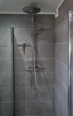 a shower with a shower head in a bathroom at Sleep Inn Amsterdam in Amsterdam