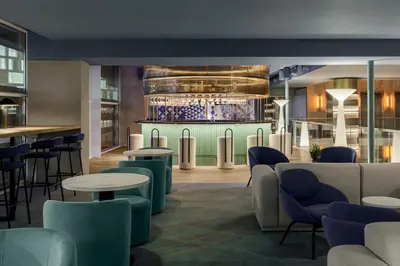 a lobby with tables and chairs and a bar at Room Mate Aitana, Amsterdam in Amsterdam