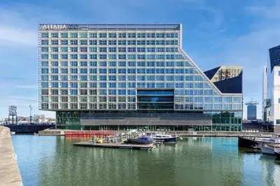 a building with boats in the water in front of it at Room Mate Aitana, Amsterdam in Amsterdam