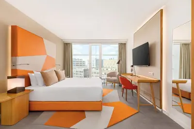 a hotel room with a bed and a desk and a desk at Room Mate Aitana, Amsterdam in Amsterdam