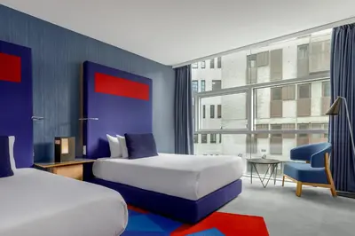 a hotel room with two beds and a window at Room Mate Aitana, Amsterdam in Amsterdam