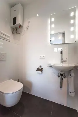 a white bathroom with a toilet and a sink at Amsterdam Beach Zandvoort Studio s in Zandvoort