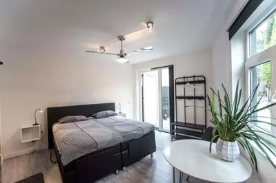 a bedroom with a bed and a table with a potted plant at Amsterdam Beach Zandvoort Studio s in Zandvoort