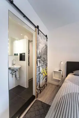 a bedroom with a door open to a bathroom with a sink at Amsterdam Beach Zandvoort Studio s in Zandvoort