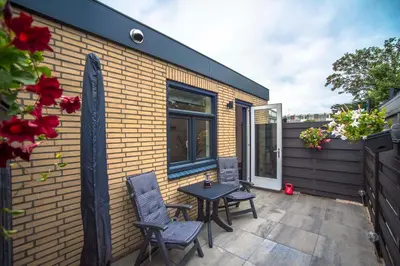 a small patio with two chairs and a table at Amsterdam Beach Zandvoort Studio s in Zandvoort