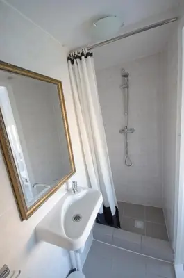 a bathroom with a sink and a shower with a mirror at Pension Oranje in Zandvoort