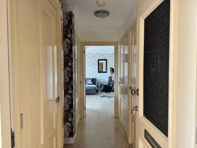 a hallway with a person sitting in a chair in a room at Appartement Villa Eva Rosa in Wijk aan Zee