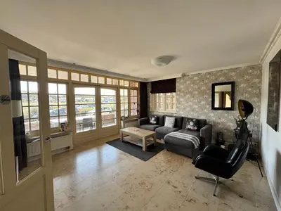 a living room with a couch and a chair at Appartement Villa Eva Rosa in Wijk aan Zee