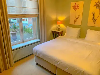 a bedroom with a white bed and a window at Hotel Beijers in Utrecht