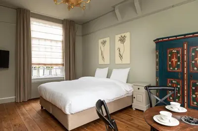 a bedroom with a bed and a table at Hotel Beijers in Utrecht