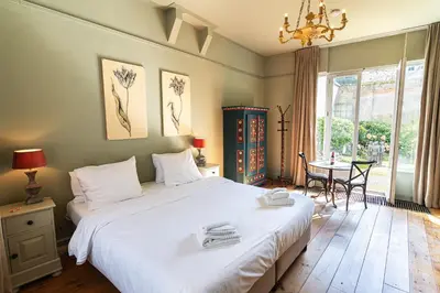 a bedroom with a large white bed and a table at Hotel Beijers in Utrecht