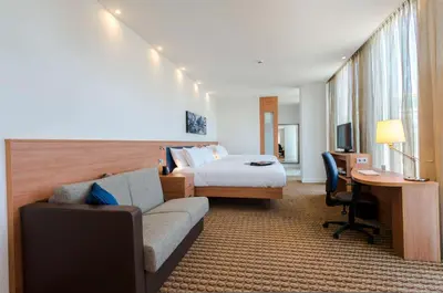a hotel room with a bed and a couch and a desk at Hampton By Hilton Amsterdam Arena Boulevard in Amsterdam