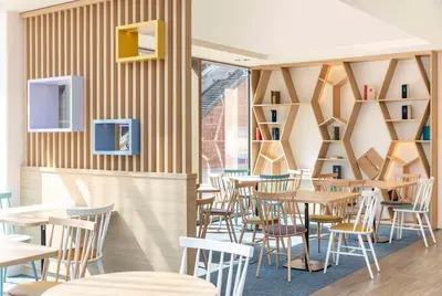 a restaurant with wooden walls and tables and chairs at Hampton By Hilton Amsterdam Arena Boulevard in Amsterdam