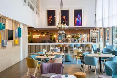 a restaurant with tables and chairs and a bar at Hampton By Hilton Amsterdam Arena Boulevard in Amsterdam