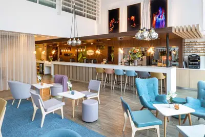 a restaurant with tables and chairs and a bar at Hampton By Hilton Amsterdam Arena Boulevard in Amsterdam